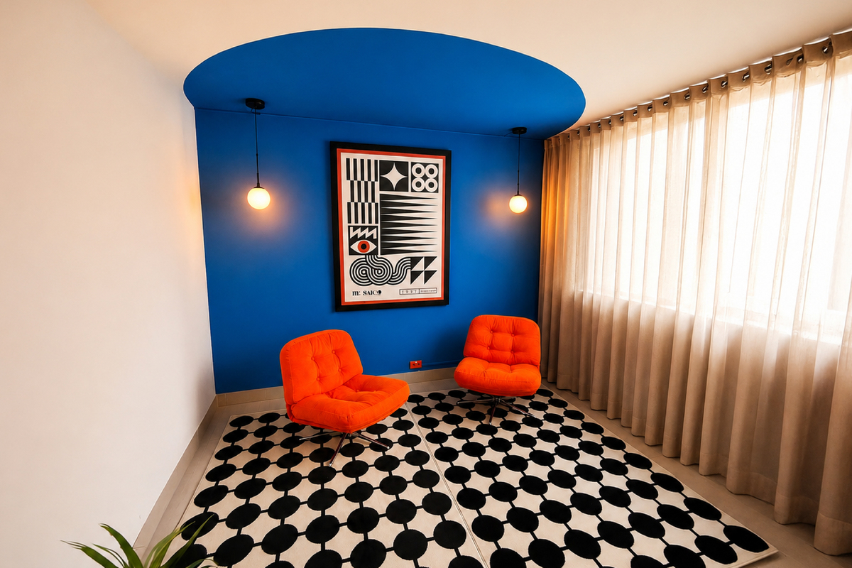 Sala con diseño moderno que tiene una pared azul, dos sillones naranjas, alfombra con patrón blanco y negro y un cuadro geométrico.